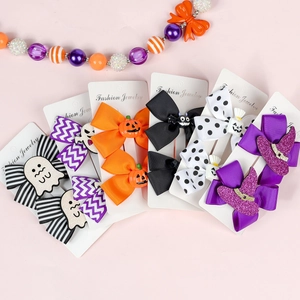 Detail of Halloween bow hair clips with ghosts and pumpkins on a display card