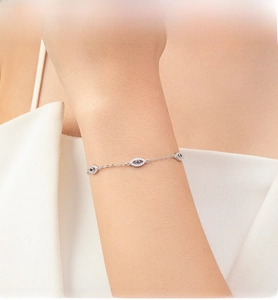 Detailed view of S925 sterling silver evil eye bracelet with blue crystals on model wrist