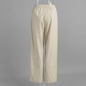 Detail of light beige wide-leg pants showing elastic waistband and fabric texture
