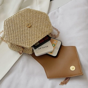 Chic beige woven straw crossbody bag with gold chain strap and spacious interior