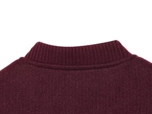 Dettaglio dello scollo a coste di una morbida giacca in maglia bordeaux da donna