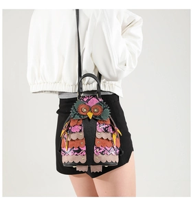 Detailed view of owl-shaped PU leather backpack featuring snakeskin texture and rivets