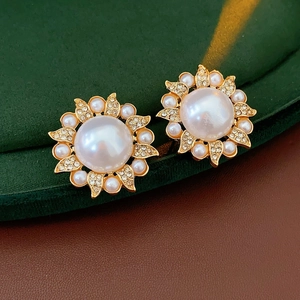 Gros plan de boucles d'oreilles vintage tournesol avec perles et strass sur velours