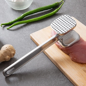 Dual-sided aluminum meat tenderizer hammer on a wooden board with raw steak and spices