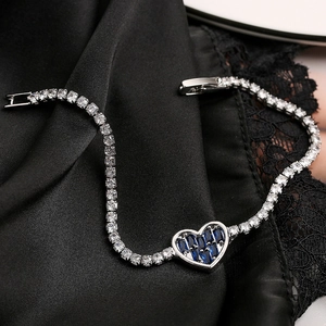 Elegant silver-toned tennis bracelet featuring deep blue heart-shaped baguette-cut stones