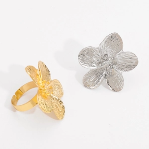 Detail of adjustable flower rings in gold and silver with fine brushed metal texture