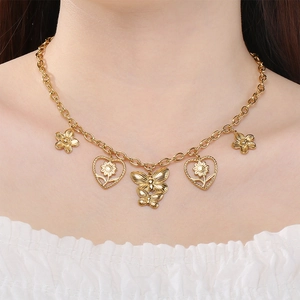 Vue détaillée d'un collier doré en acier inoxydable avec breloques papillon et cœur fleuri