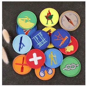 Detail view of round embroidered patches with outdoor and scout motifs on dark background
