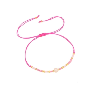 Pink woven pearl bracelet with gold beads and adjustable cord on white background