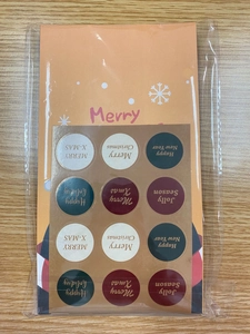Detailed close-up of festive Christmas stickers and orange greeting cards in packaging