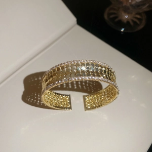 Macro detail of gold multi-layer cuff bracelet with sparkling zircon scales and rhinestones