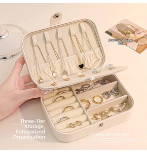 Close-up of portable cream jewelry box with necklace hooks and velvet ring slots