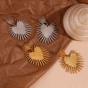 Detailed macro view of gold and silver sunburst texture earrings with a metallic finish