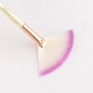 Macro shot of fan-shaped highlighter brush with white to purple gradient soft bristles