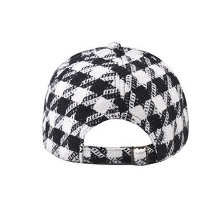 Detail of houndstooth baseball cap featuring an adjustable brass metal buckle closure