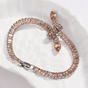 Detailed macro of a silver tennis bracelet with champagne zircon stones and snake head charm