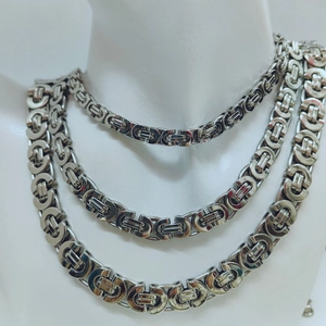 Three silver Byzantine chain necklaces of varying thickness on a mannequin bust