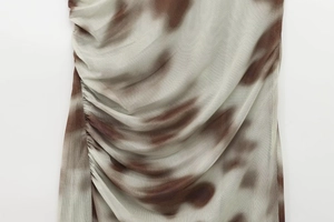 Detailaufnahme von braun-beigem Netzstoff mit Batikmuster und gerafften Details
