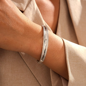 Detailed view of silver finish bracelet with pavé-set zircons and elegant geometric motif