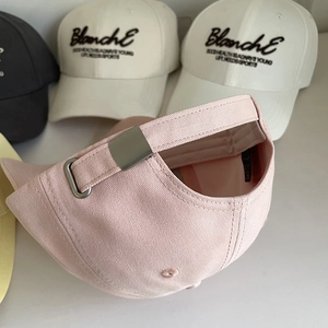 Détail de boucle métallique et broderie sur casquettes de baseball en sergé de coton