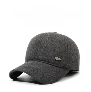 Detail of dark grey baseball cap with textured wool fabric and metal sports emblem