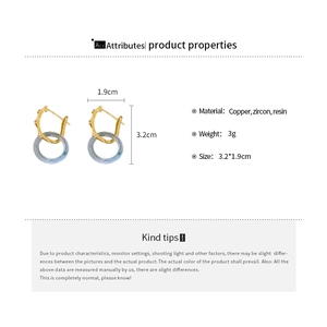 Détail des boucles d'oreilles géométriques vintage avec métal doré et résine marbrée
