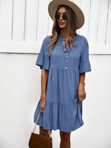 Détail d'une robe bleue à col en V avec cordon et tissu plissé sur un modèle d'été