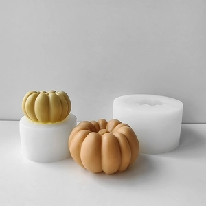 Detailed view of 3D pumpkin silicone molds alongside finished orange and yellow candles