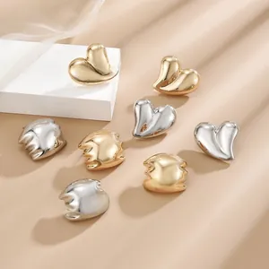 Detailed view of irregular waterdrop earrings in polished gold and silver mirror finishes
