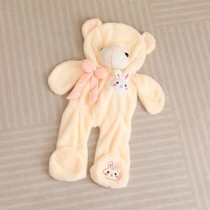 Light yellow plush teddy bear romper with pink bow and rabbit embroidery on beige mat