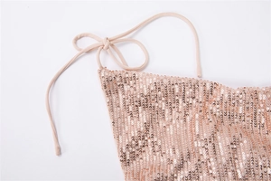 Détail du tissu à paillettes rose doré et du nœud de la bretelle beige sur la robe
