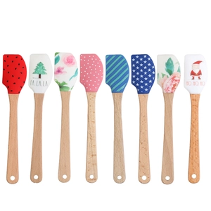 Silicone Christmas spatulas with festive patterns and durable wooden handles on white background