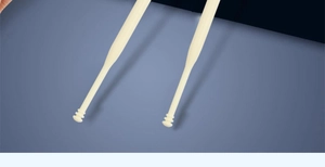 Close-up of double-ended nasal hair trimmers with ring-textured head for manual grooming