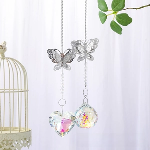 Detail of crystal butterfly wind chime pendants with heart and ball shapes in sunlight