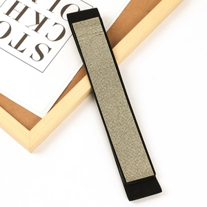 Detail of wide elastic black belt featuring rows of sparkling gold rhinestones decoration