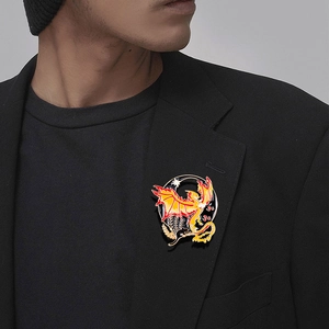 Vintage dragon lapel pin with yellow and red enamel on a black suit blazer collar