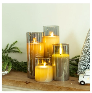 Cozy holiday scene with four grey glass LED candles in varying heights on a wooden table