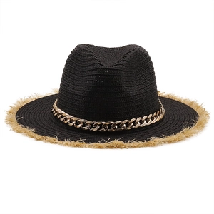 Close-up of black raffia sun hat featuring a gold chunky chain and fringed straw edge
