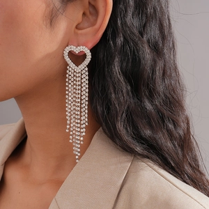 Silver heart tassel earrings with sparkling rhinestones worn by a model for a chic look
