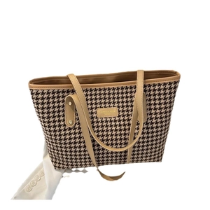 Vintage houndstooth tote bag with beige leather handles and fashion logo on white background