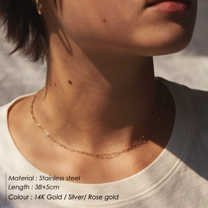 Gros plan d'un collier chaîne trombone en acier inoxydable plaqué or 14K sur un mannequin