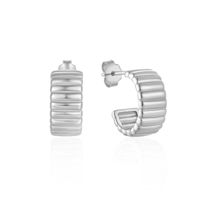 Macro detail of silver C-shape hoop earrings featuring a textured croissant ribbed design