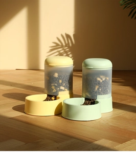 Detail view of high capacity gravity pet food dispensers in yellow and mint green