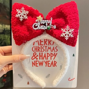 Detail of red plush Christmas bow headband with silver snowflakes and Merry Christmas text