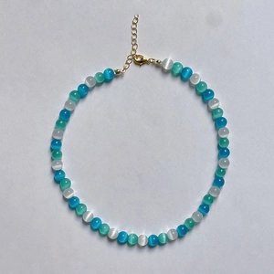 Detail of glacier blue cat eye stone necklace with gold lobster clasp and extension chain