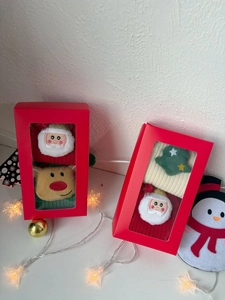 Detail of Christmas gift box socks featuring 3D plush Santa and reindeer embroidery