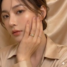 Close-up of gold quilted texture ring and dainty rhinestone band on a hand