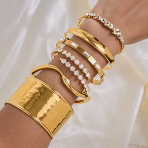 Ensemble de bracelets dorés en acier inoxydable avec zircons sur fond de soie