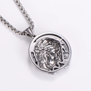 Macro detail of silver stainless steel pendant featuring a religious relief and box chain