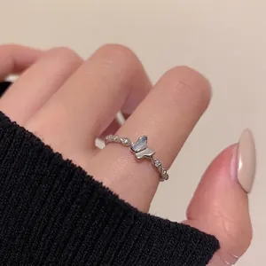 Micro-set zircon butterfly ring with twisted silver band and heart detail worn by a model